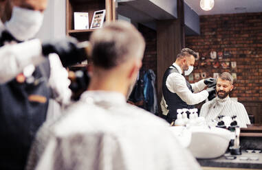 Gutaussehender Hipster-Mann, der einen Friseur und einen Haarstylisten im Friseursalon besucht. - HPIF27658