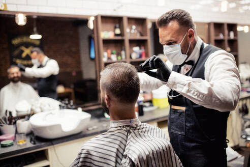 Gutaussehender Hipster-Mann, der einen Friseur und einen Haarstylisten im Friseursalon besucht. - HPIF27667