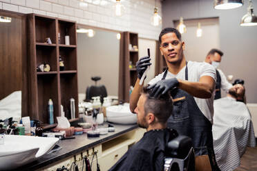 Ein Hipster-Mann besucht einen Friseur und einen Hairstylisten in einem Friseursalon. - HPIF27676