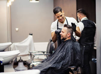 Ein Hipster-Mann besucht einen Friseur und einen Hairstylisten in einem Friseursalon. - HPIF27716