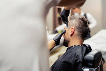 Ein Hipster-Mann besucht einen Friseur und einen Hairstylisten in einem Friseursalon. - HPIF27721