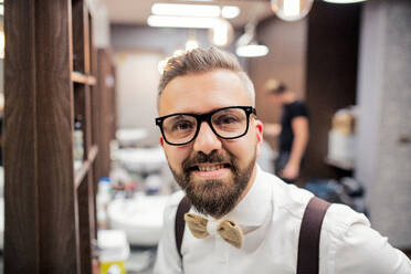 Ein Porträt eines gutaussehenden Hipster-Mannes, der in einem Friseursalon steht, Kopierraum. - HPIF27736