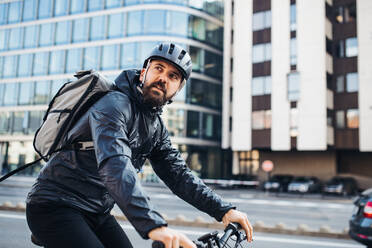 Männlicher Hipster-Kurier mit Fahrrad auf einer Straße in der Stadt, der Pakete ausliefert, Kopierraum. - HPIF27738