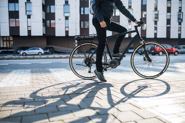 Mittelteil eines nicht erkennbaren männlichen Hipster-Kuriers mit Fahrrad auf einer Straße in der Stadt, der Pakete ausliefert, Kopierraum. - HPIF27755