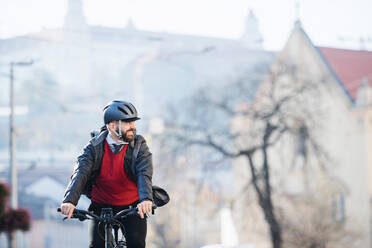 Hipster businessman commuter with bicycle traveling to work in city. Copy space. - HPIF27777