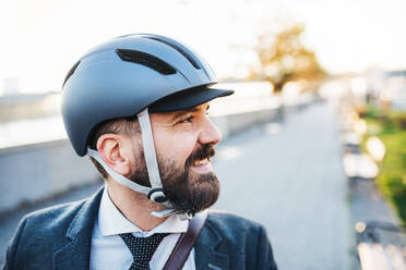 Hipster Geschäftsmann mit Fahrradhelm auf dem Heimweg von der Arbeit in der Stadt. - HPIF27820