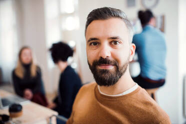 A portrait of young hipster businessman with colleagues in a modern office. - HPIF27839