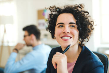 A portrait of young cheerful businesswoman with colleagues in a modern office. - HPIF27897