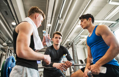 Young male friends in modern crossfit gym, standing and talking. - HPIF27967