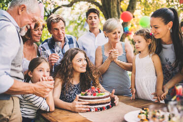 Familienfeier im Hinterhof, große Gartenparty, Geburtstagsparty, Teenager-Mädchen mit Geburtstagstorte. - HPIF28098