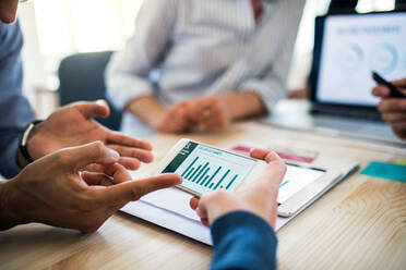 Group of businesspeople with smartphone working together in office, a midsection view. - HPIF28183