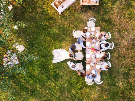 Hochzeitsempfang im Hinterhof. Braut und Bräutigam mit Familie stehen um den Tisch herum. Luftaufnahme. - HPIF28188