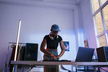 Junger DJ mit Laptop und Tonmischpult zu Hause - EBSF03515
