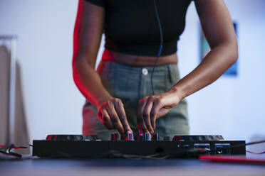 Young female Dj operating sound mixer at home - EBSF03523