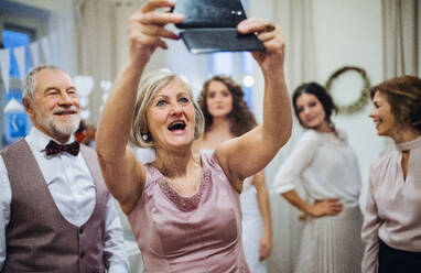 Ein fröhliches älteres Paar macht ein Selfie zu einem besonderen Anlass, sei es eine Hochzeit oder eine Geburtstagsfeier - HPIF28303