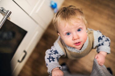 Draufsicht eines niedlichen Kleinkindes, das zu Hause nach oben schaut, Nahaufnahme. - HPIF28324