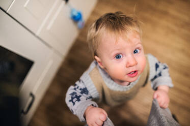 Draufsicht eines niedlichen Kleinkindes, das zu Hause nach oben schaut, Nahaufnahme. - HPIF28325
