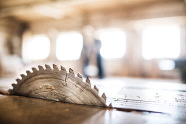 A circular saw blade in carpentry workshop. Blurred background. - HPIF28500