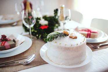 Ein weißer Kuchen auf einem für das Weihnachtsessen gedeckten Tisch zu Hause. - HPIF28554