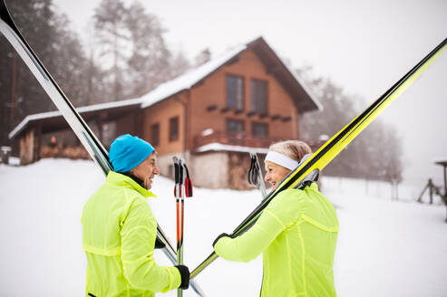 Aktives Seniorenpaar bei den Vorbereitungen zum Skilanglauf. Winterzeit. - HPIF28802