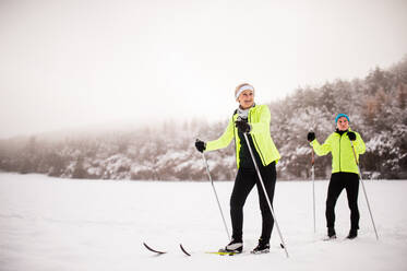 Active senior couple cross-country skiing. Winter time. - HPIF28805