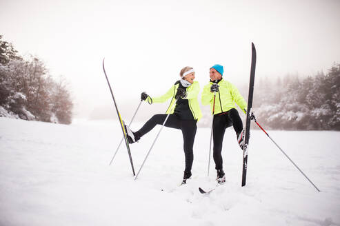 Aktives älteres Ehepaar beim Skilanglauf im Winter, das Spaß hat. - HPIF28807
