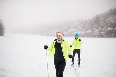 Active senior couple cross-country skiing. Winter time. - HPIF28809