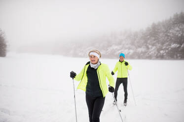 Aktives Seniorenpaar beim Skilanglauf, Winterzeit. - HPIF28809