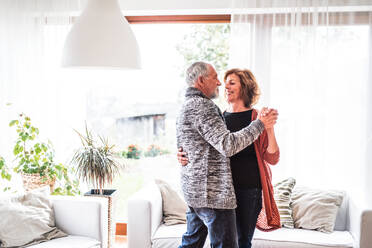 Happy senior couple relaxing at home, dancing. - HPIF28851