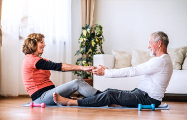 Ein glückliches älteres Ehepaar beim Sport zu Hause. - HPIF28863