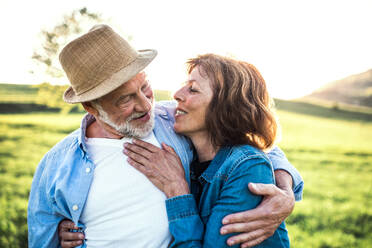 Glückliches älteres Paar draußen in der Natur im Frühling, umarmend. - HPIF28995
