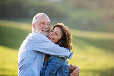 Glückliches älteres Paar draußen in der Natur im Frühling, umarmend. - HPIF28998