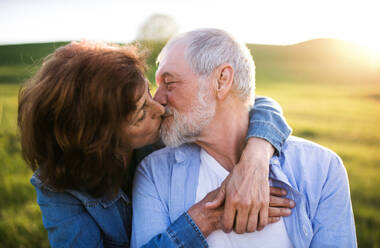Happy senior couple outside in spring nature, kissing. - HPIF29008