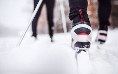 Beine eines nicht zu erkennenden aktiven Paares beim Skilanglauf, Winterzeit, Rückansicht. - HPIF29055