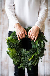 Unerkennbare Frau mit grünem Kranz, Weihnachtskomposition, Kopierraum. - HPIF29418