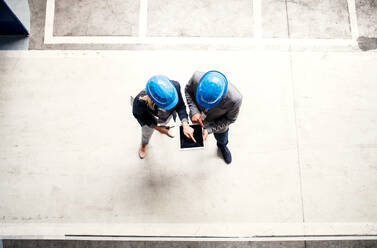 A top view of an industrial man and woman engineer with tablet in a factory, working. Copy space. - HPIF29575