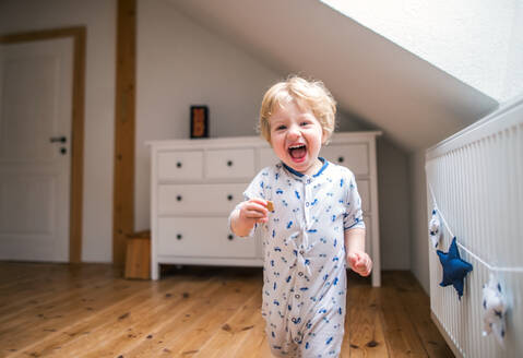 Ein glückliches Kleinkind im Schlafzimmer zu Hause, das Spaß hat. - HPIF29646