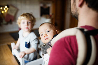 Unbekannter Vater mit zwei Kleinkindern zu Hause. Vaterschaftsurlaub. - HPIF29769