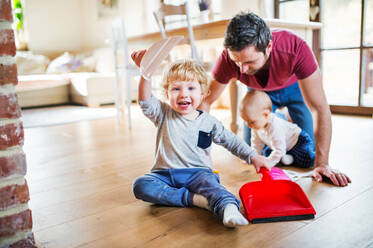 Father and two toddlers with brush and dustpan. Paternity leave. - HPIF29777
