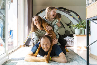 Fröhliche Familie genießt mit VIzsla-Hund zu Hause - NDEF00639