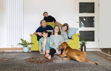 Familie mit Vizsla-Hund entspannt sich im heimischen Wohnzimmer - NDEF00650