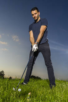 Mann hält Golfschläger auf Gras unter Himmel - STSF03724