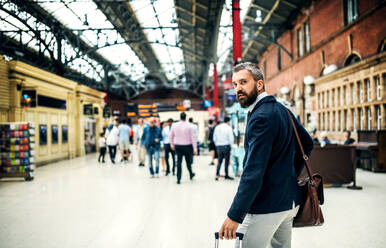 Hipster-Geschäftsmann mit Koffer zu Fuß in der U-Bahn-Station in London. Raum kopieren. - HPIF29931