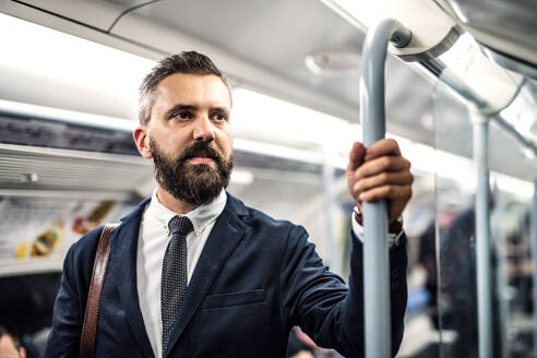 Seriöser Hipster-Geschäftsmann, der mit der U-Bahn fährt. Raum kopieren. - HPIF29943