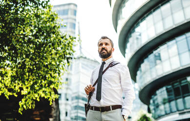 Hipster businessman walking outdoors on the street in London city. Copy space. - HPIF29970