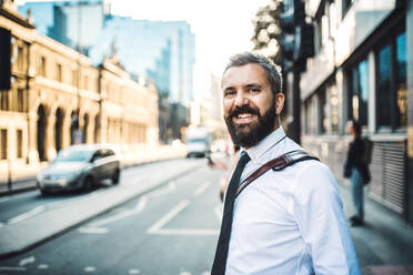 Ein lachender Hipster-Geschäftsmann, der auf einer Straße in London steht. Raum kopieren. - HPIF30001