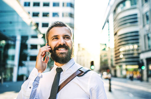 Nahaufnahme eines Hipster-Geschäftsmannes mit Smartphone in der Stadt, der einen Anruf tätigt. Raum kopieren. - HPIF30007