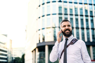 Nahaufnahme eines Hipster-Geschäftsmannes mit Smartphone in der Stadt, der einen Anruf tätigt. Raum kopieren. - HPIF30012