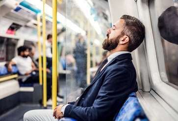 Müder schlafender Hipster-Geschäftsmann in der U-Bahn in der Stadt, auf dem Weg zur Arbeit. - HPIF30054