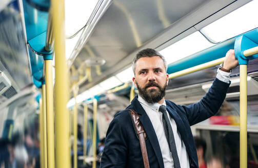 Ernster Hipster-Geschäftsmann in der U-Bahn in der Stadt, auf dem Weg zur Arbeit. - HPIF30055